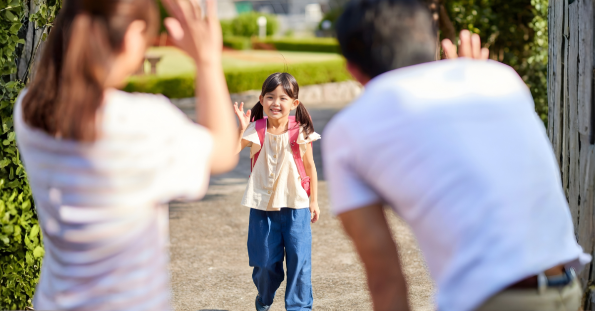 A smiling child with a backpack waves between two parents, illustrating managing transitions between homes in a calm and supportive way.