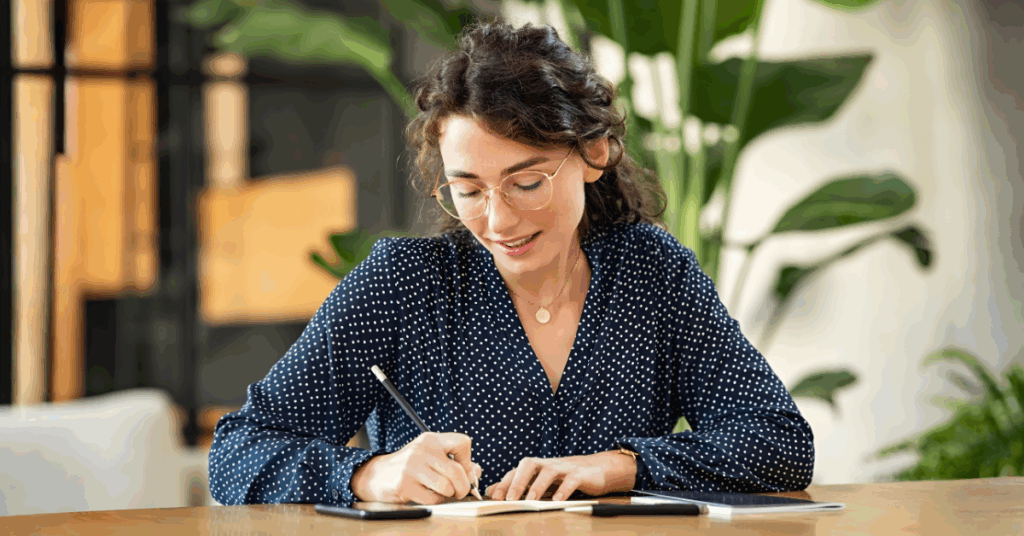 Woman calmly writing notes as she documents co-parenting concerns in a balanced and healthy way.