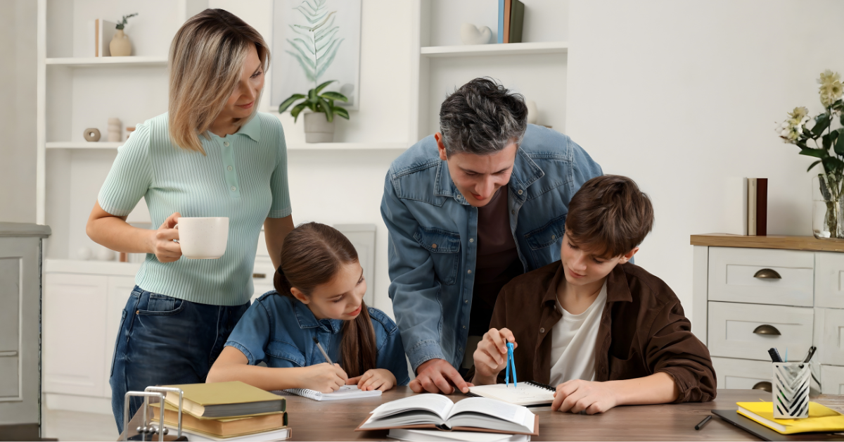 A mother and father helping their two children with homework together at a table, representing teamwork in parallel parenting and co-parenting.
