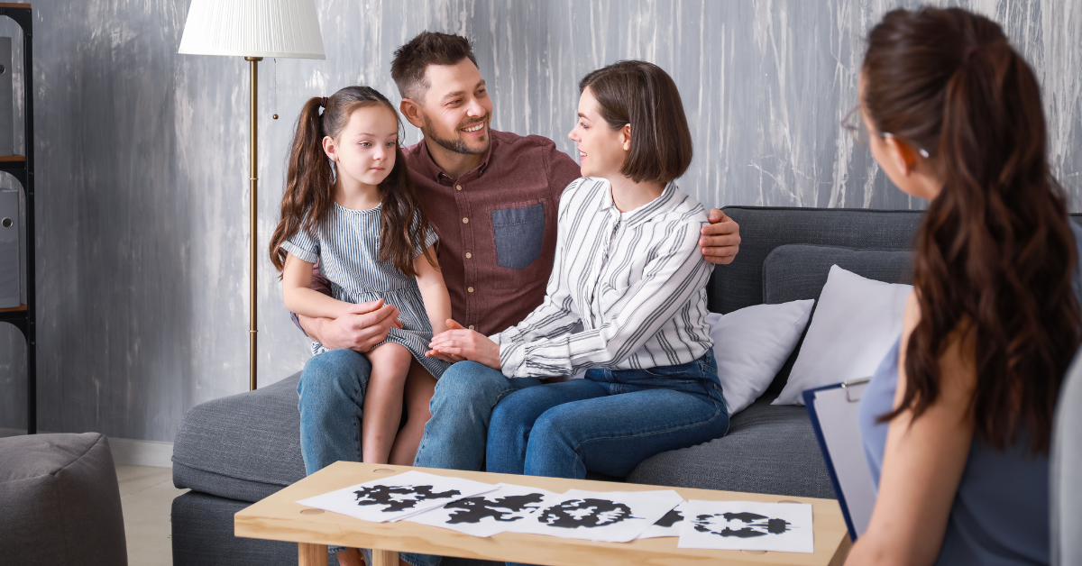 Parents discussing a parenting plan for their special needs or neurodivergent child with a therapist, focusing on emotional support and structure.